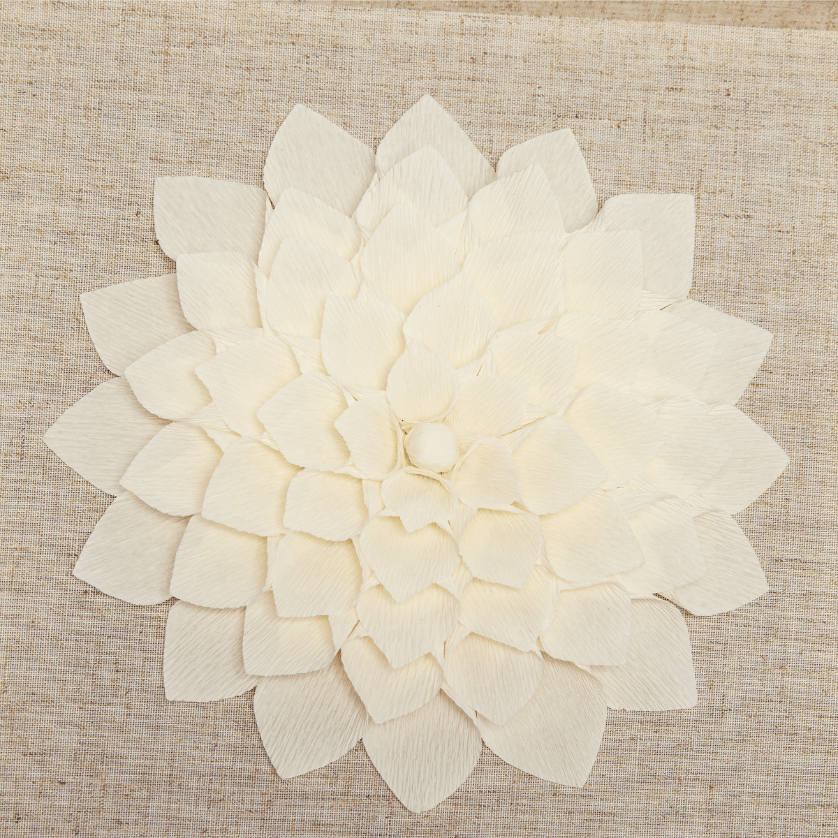 Detailansicht der handgefertigten Krepppapier-Blüte, filigrane Handarbeit, Wandkunst.